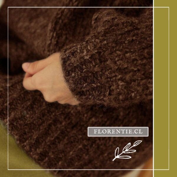 Close-up de la textura esponjosa y ligeramente peluda del chaleco café chocolate oversize, mostrando el punto grueso artesanal y el remate acanalado del puño en tono marrón oscuro.